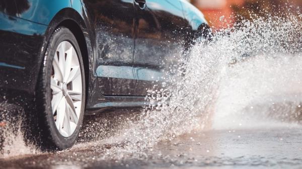 Close up of car driving through puddle