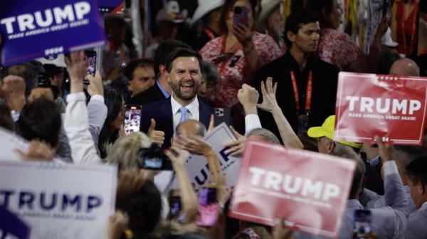 J.D. Vance surrounded by Trump signs 